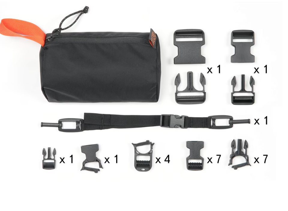 Set of outdoor gear components including a Mystery Ranch black bag, straps, and buckles on a white background.