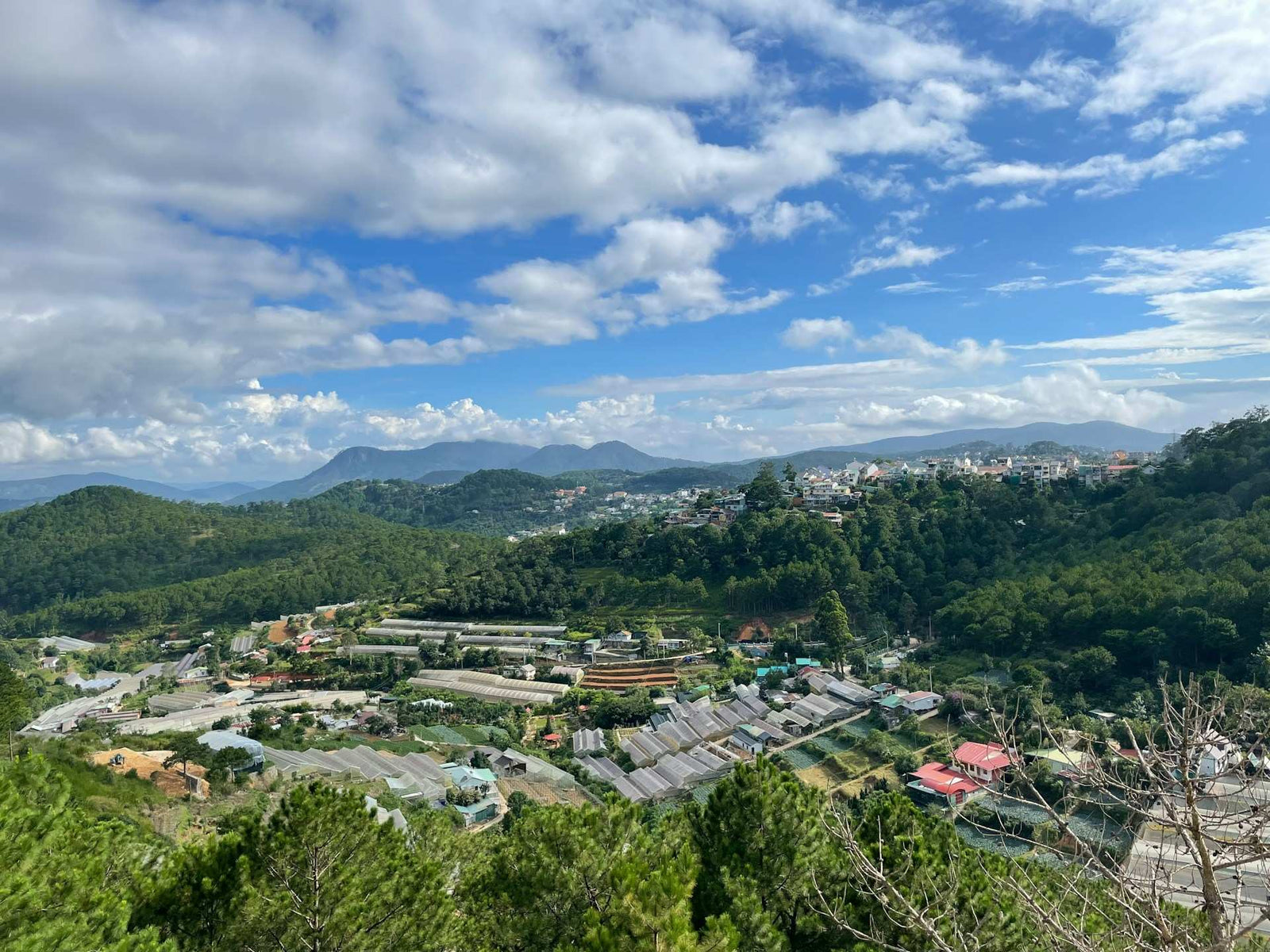 mountain valley landscape with residential areas and forested hills under blue sky