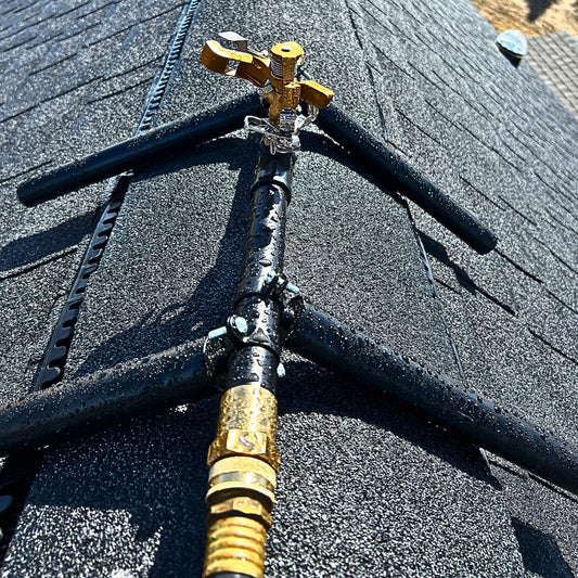 Rooftop sprinkler head mounted for exterior wildfire ember defense on residential roofs.