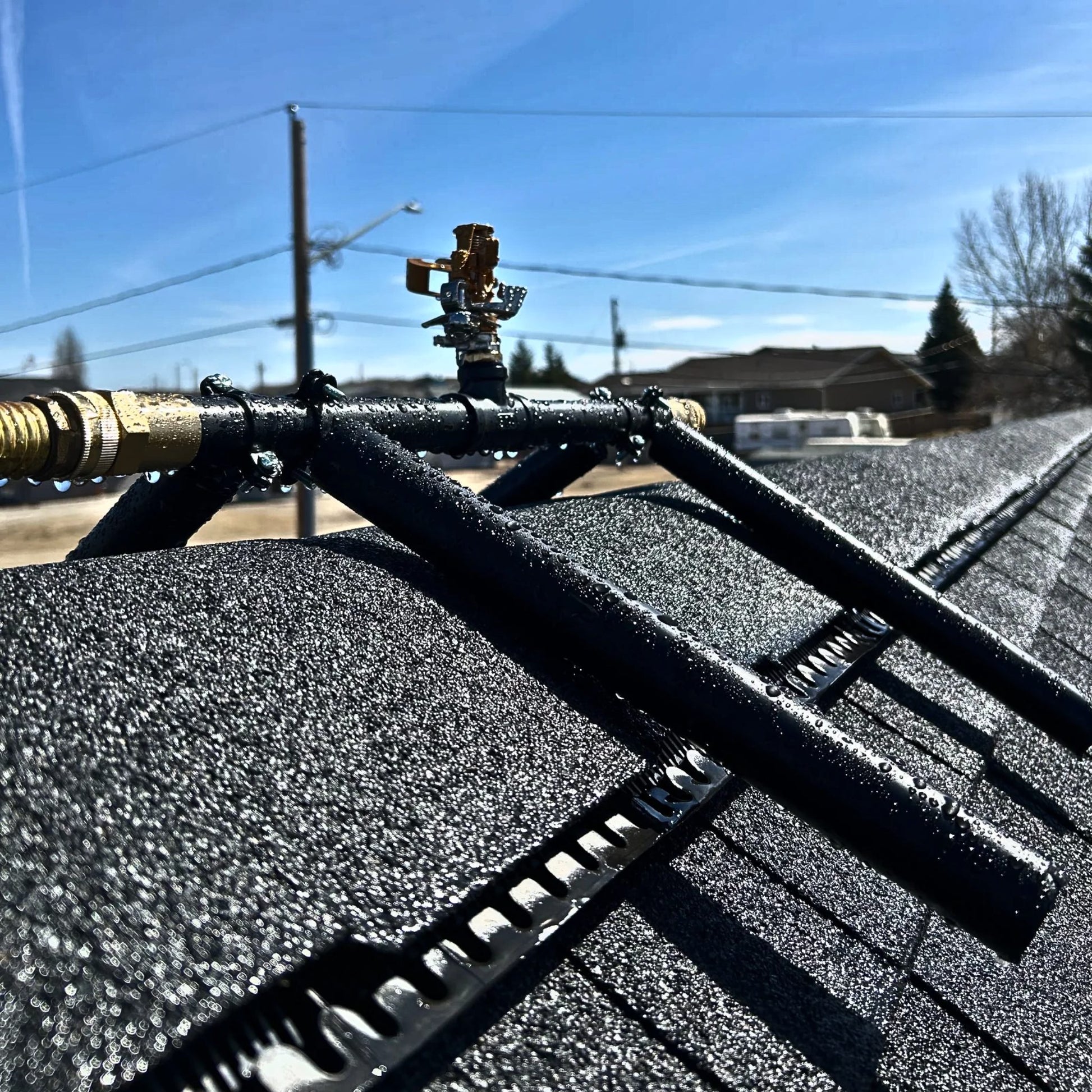 Rooftop-mounted sprinkler assembly used for exterior wildfire ember defense on residential roofs.