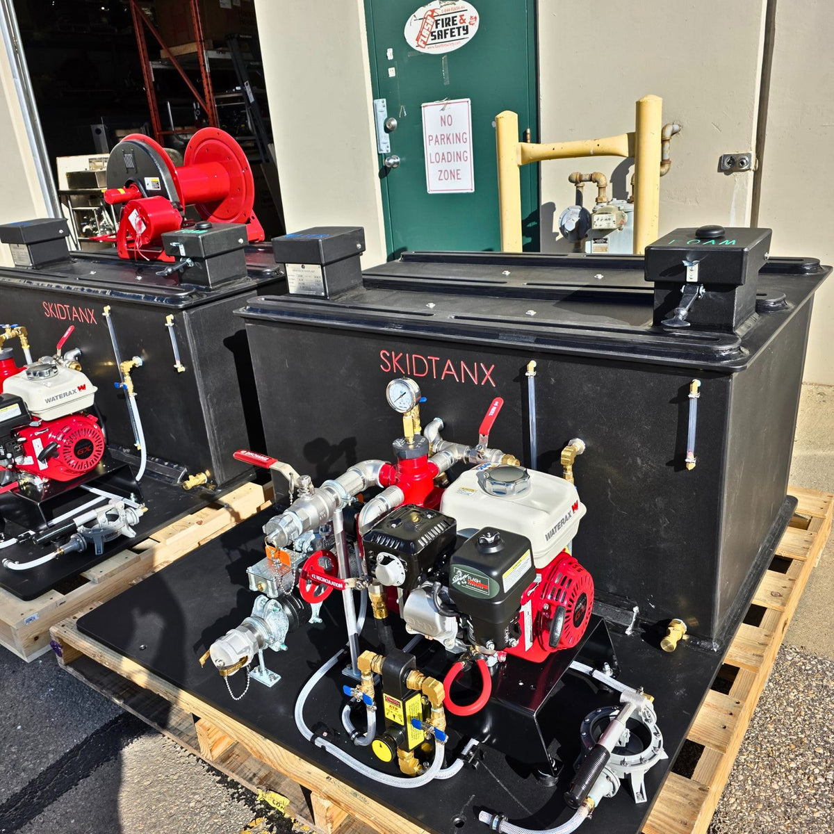 SKIDTANX custom skid deck with WATERAX pump, plumbing assembly, and hose reel system for wildland firefighting.